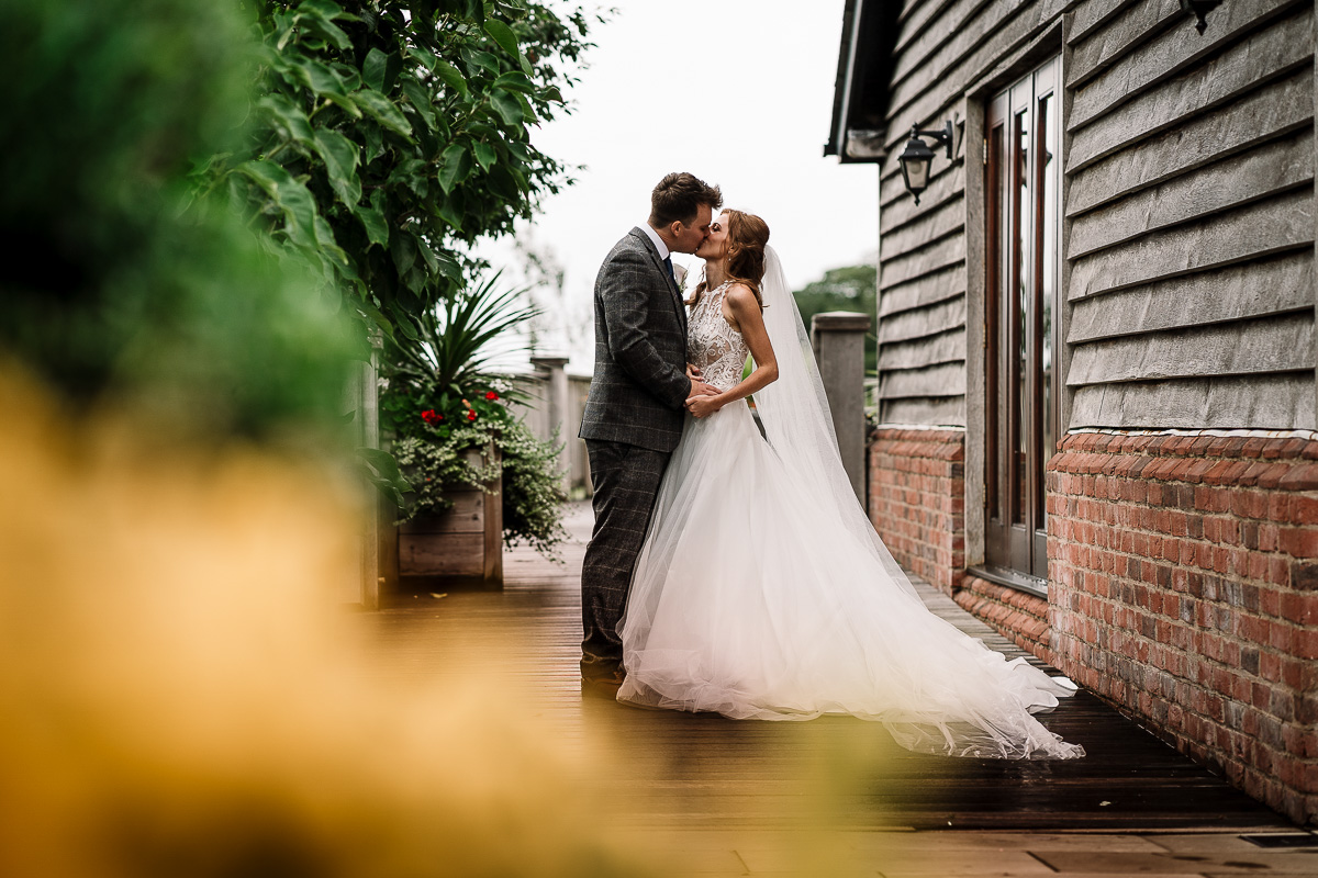 Bride and groom kissing by the barn